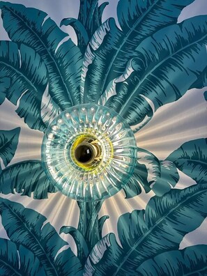 A ceiling with a central light fixture surrounded by leaf-like patterns. - Trendy Canette Hotel (Paris)