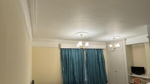 A hotel room with a bed, a desk, a television, and a wardrobe. - Langford Hotel, Brighton & Hove (Hove)