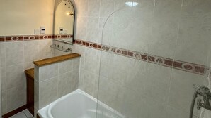 A modern bathroom with a freestanding bathtub, a shower, and a mirror above the sink. - Langford Hotel, Brighton & Hove (Hove)