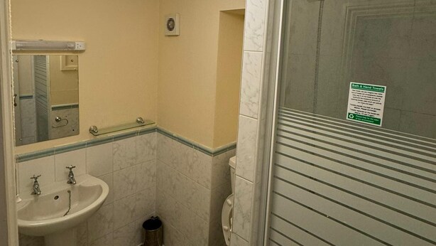 Un baño pequeño con lavabo, espejo, inodoro y cabina de ducha.