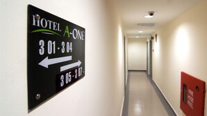A hotel hallway with directional signs indicating room numbers 301-304 and 305-307. - Hotel A-One (Kuala Lumpur)