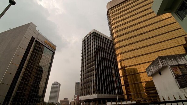 A cityscape with modern high-rise buildings, including a prominent building with a grid-like facade and another with a curved design. - Hotel A-One (Kuala Lumpur)