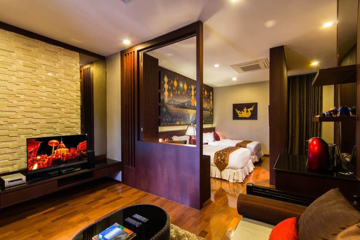 Een hotelkamer met een televisie, een bed, een bureau en uitzicht op een stadsbeeld.