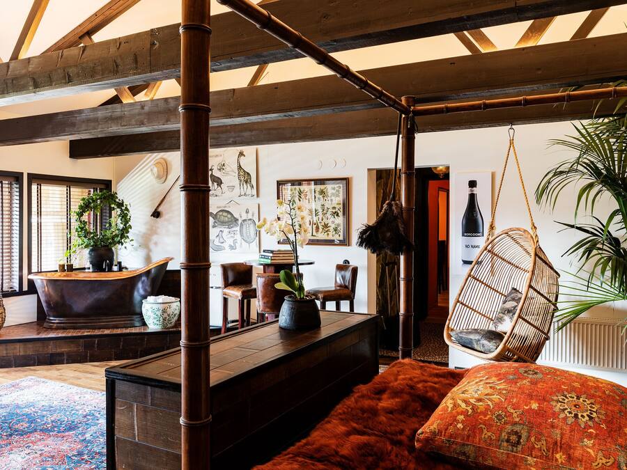 Ein Zimmer mit einer großen Badewanne, einem Hängesessel und einem gemütlichen Sofa.