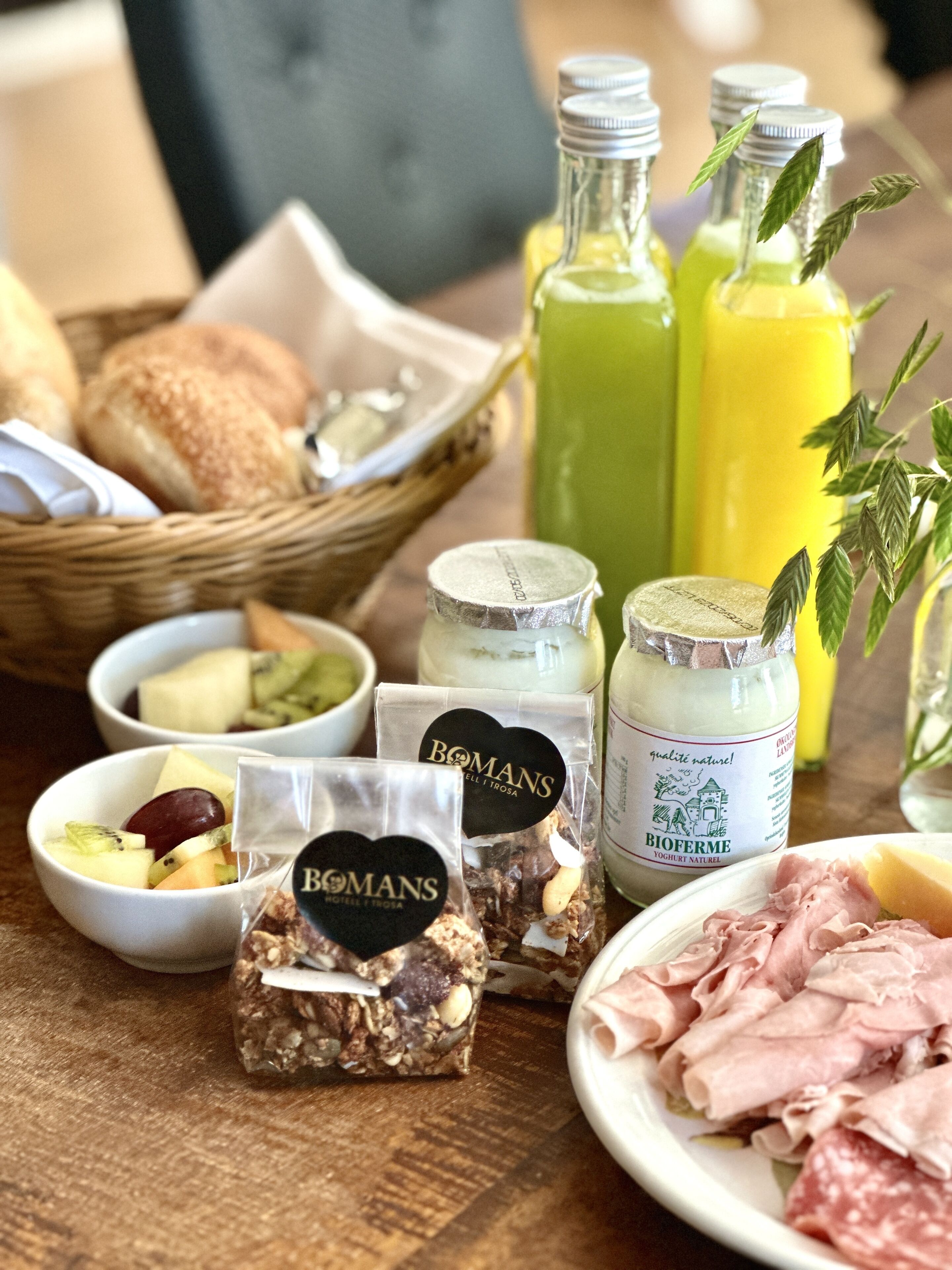 Ett frukostbord med olika sorters mat, inklusive bröd, ost, frukt och kött.