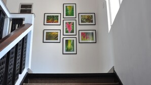 A staircase with a handrail and a wall with six framed artworks. - Comfort@15 Hotel Colombo (Colombo)