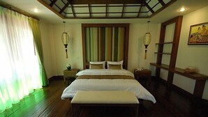 A bedroom with a wooden floor, a bed with white bedding, a bench, two bedside tables, and a wall-mounted shelf. - Villa Korbhun Khinbua (Chiang Mai)