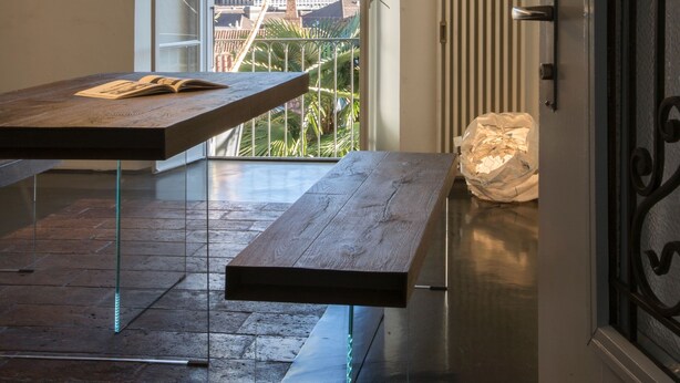 A modern interior with a long table, a view of a bridge, and a door with a decorative handle. - Caffè dell'Arte Boutique Rooms Locarno (Locarno)