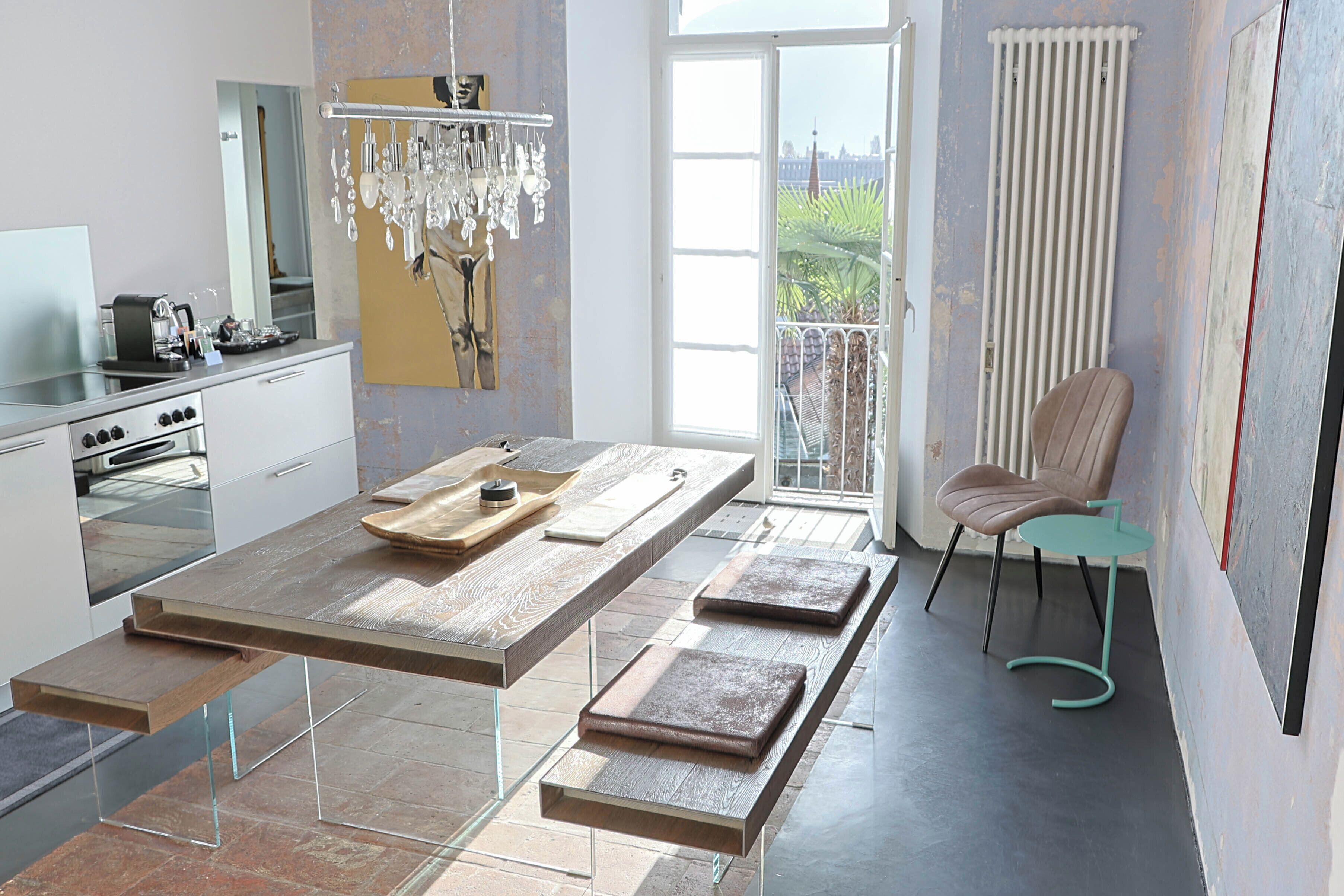 Una cocina moderna con una isla grande, un comedor con una silla y vistas al exterior.