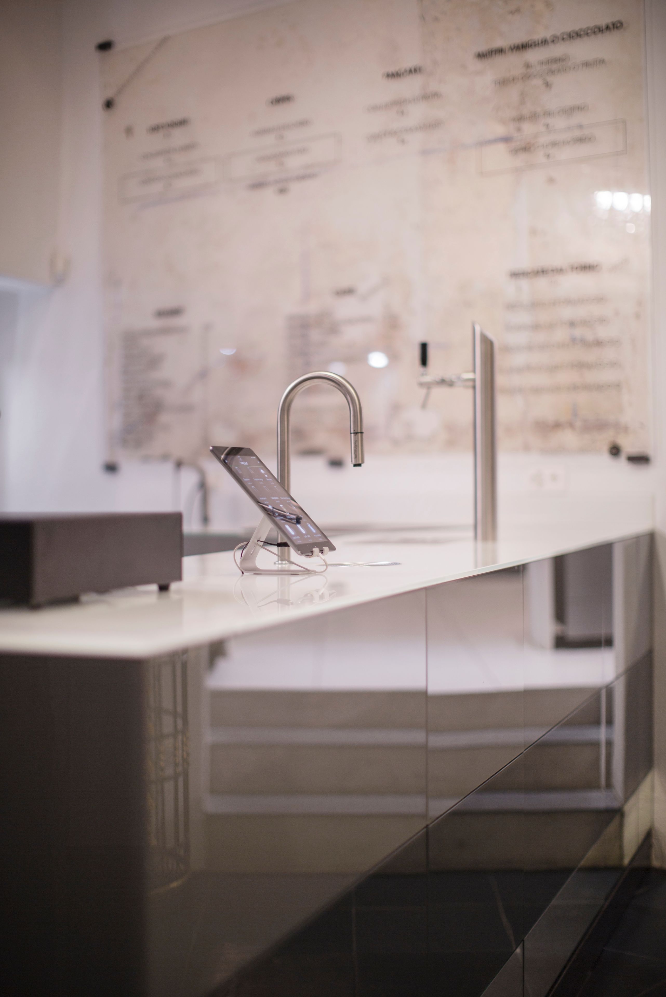 A modern bathroom with a sleek, metallic faucet and a glass-embedded control panel.