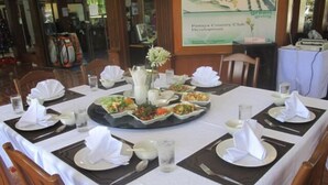A formal dining table set for a meal with multiple dishes and a centerpiece. - Pattaya Country Club (Bang Lamung)