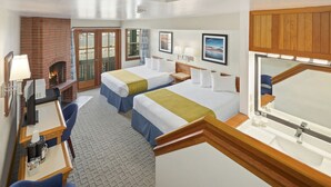 A hotel room with two beds, a desk with a computer, a fireplace, and a bathroom with a large mirror. - Canadian Princess Lodge & Marina (Ucluelet)