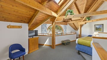 Cozy retreat with a high ceiling, skylight, and comfortable bed.