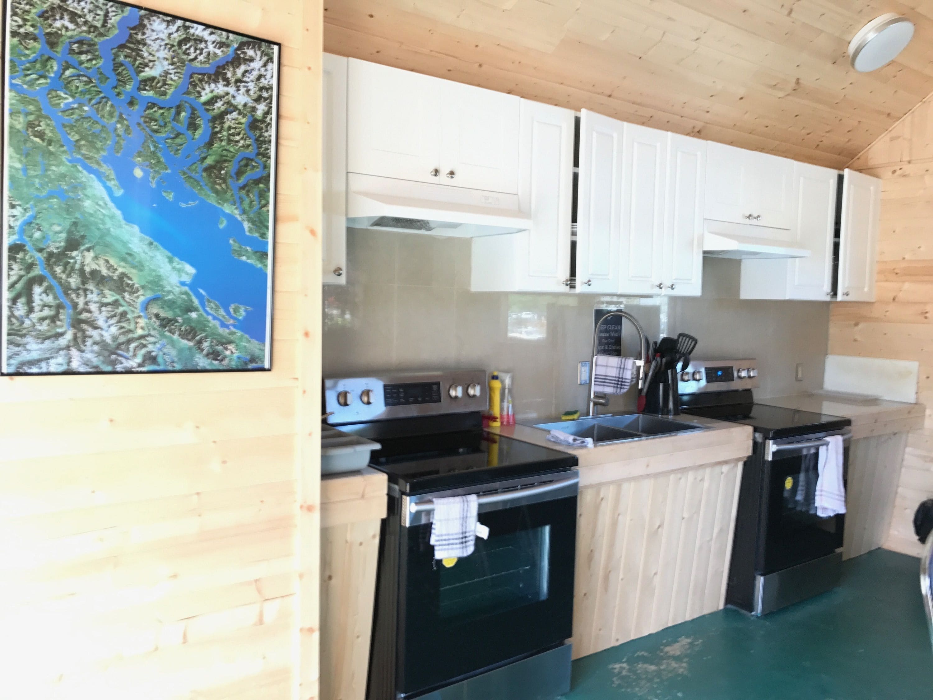 A kitchen with white cabinets, a stainless steel stove, and a sink.