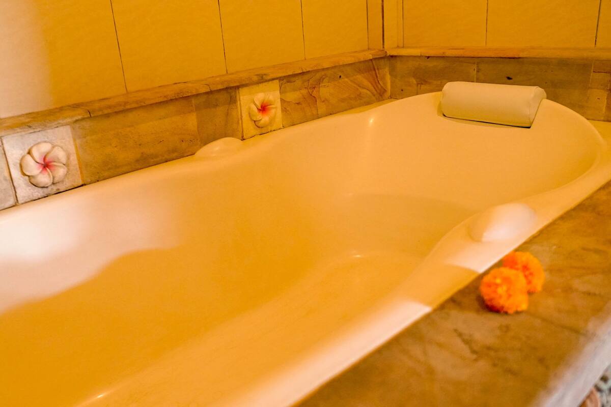 Una bañera con una decoración floral en la pared.