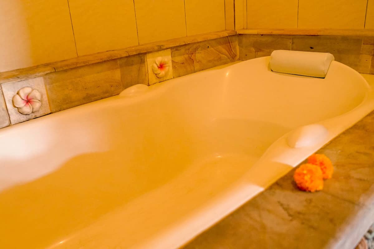 Deluxe kamer | Badkamer | Een bad/douchecombinatie, gratis toiletartikelen, een haardroger