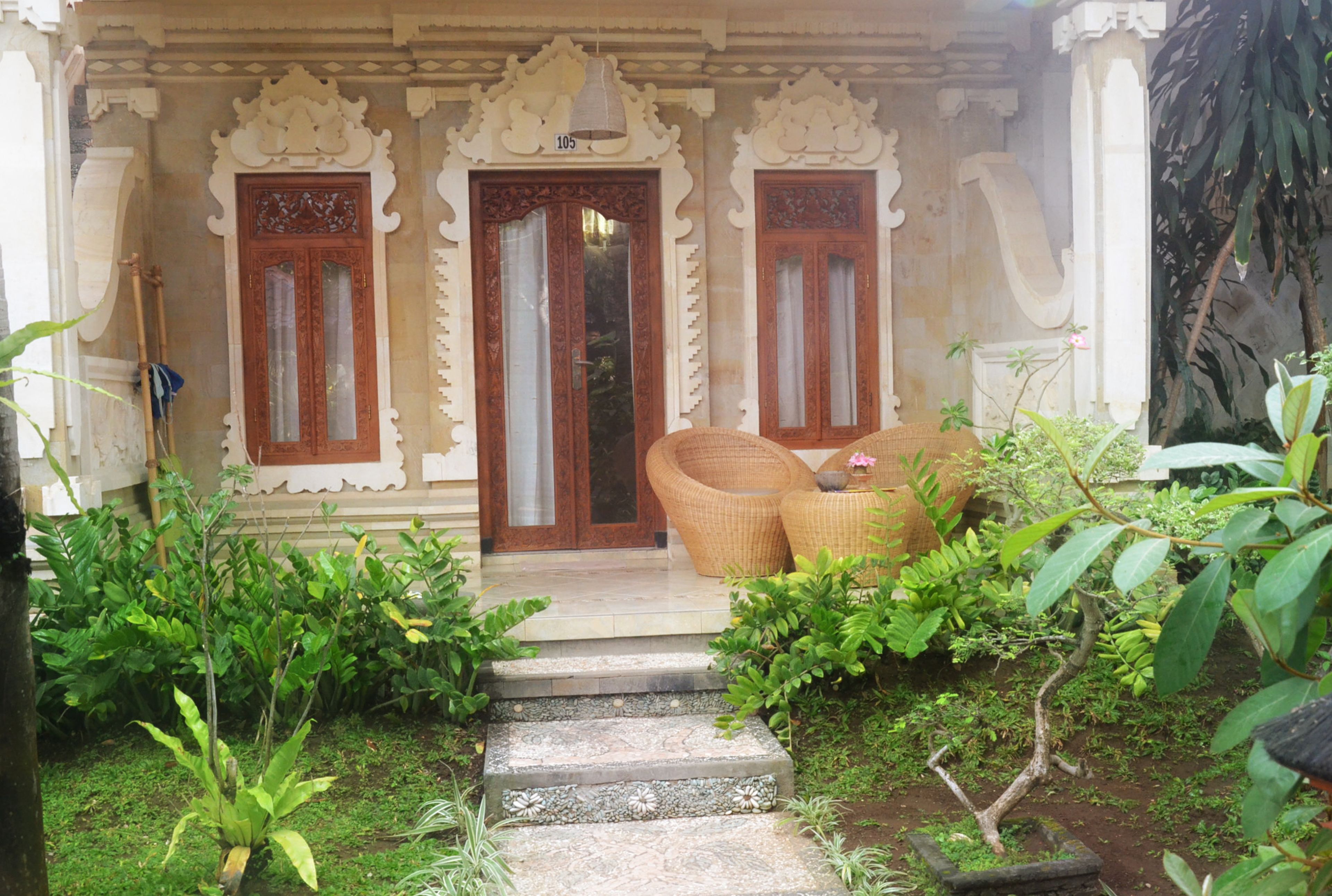A traditional building entrance with ornate doors and steps leading to a porch area.