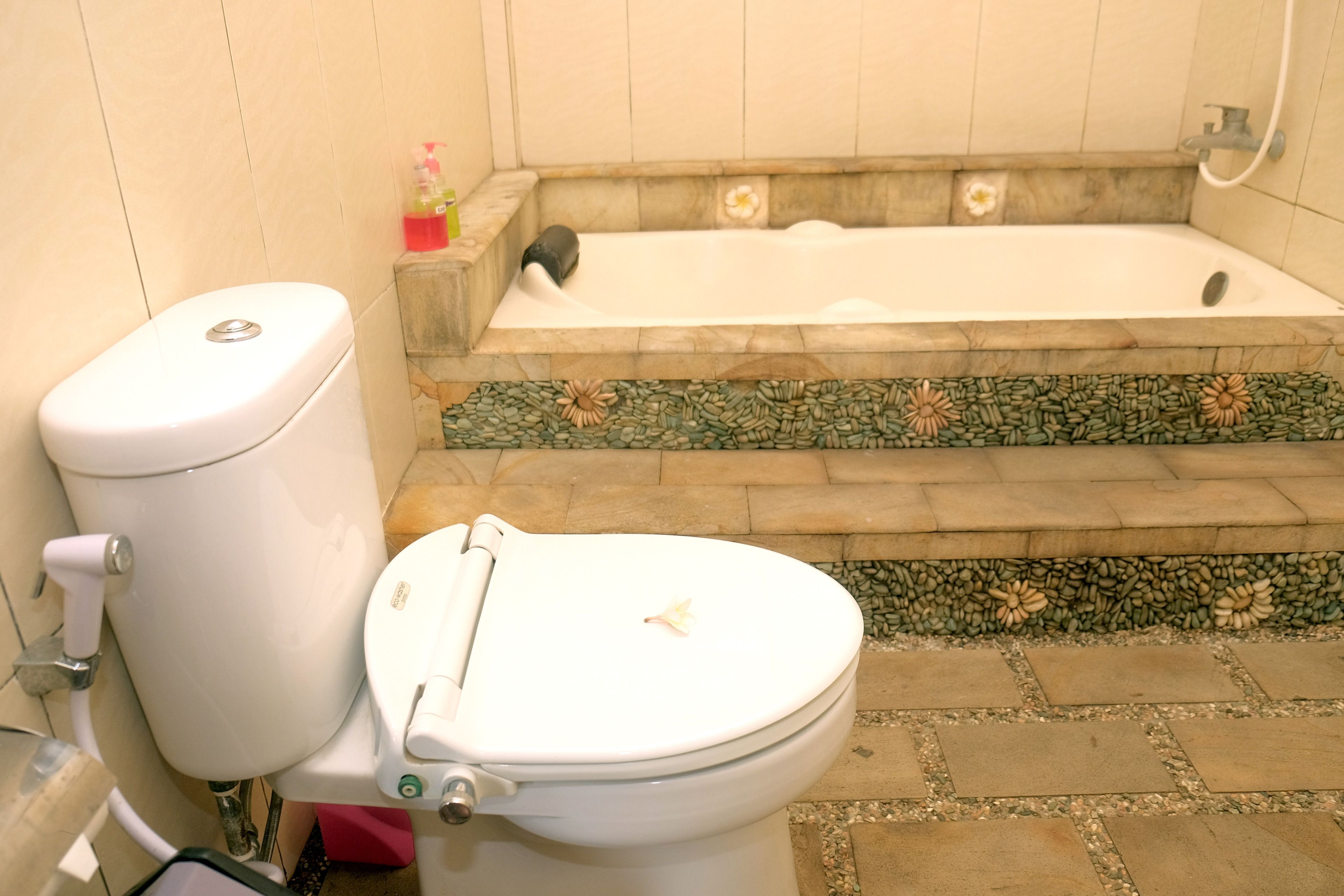 A bathroom with a toilet, a bathtub, and a shower.