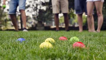 A grassy area with colorful balls and people standing in the background.