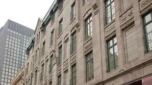 A row of traditional European-style buildings with uniform facades, large windows, and awnings. - Hotel Bonaparte  (Montreal)
