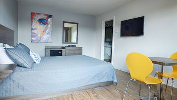 A modern bedroom with a bed, bedside table, and a desk.