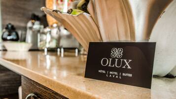 A hotel sign with the name 'OLUX' and mentions 'HOTEL | MOTEL | SUITES | LAVAL'.