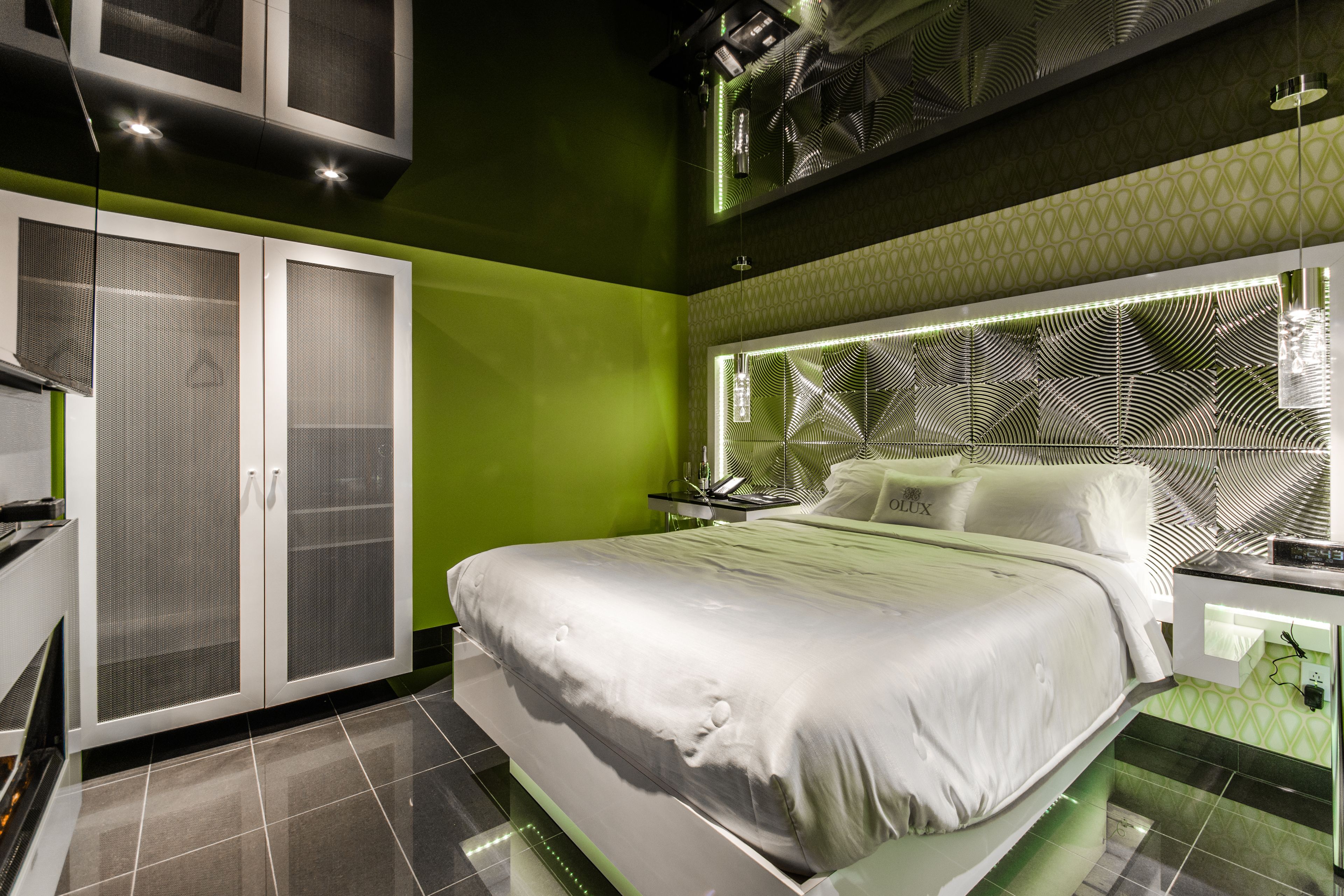 Une chambre moderne avec un grand lit, une armoire et un motif mural original.