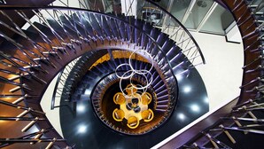 Eine Wendeltreppe mit einer zentralen, runden Plattform und Sitzgelegenheit.