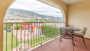 A balcony with a view of a motor inn and a mountainous landscape. - Westridge Motor Inn (Osoyoos)
