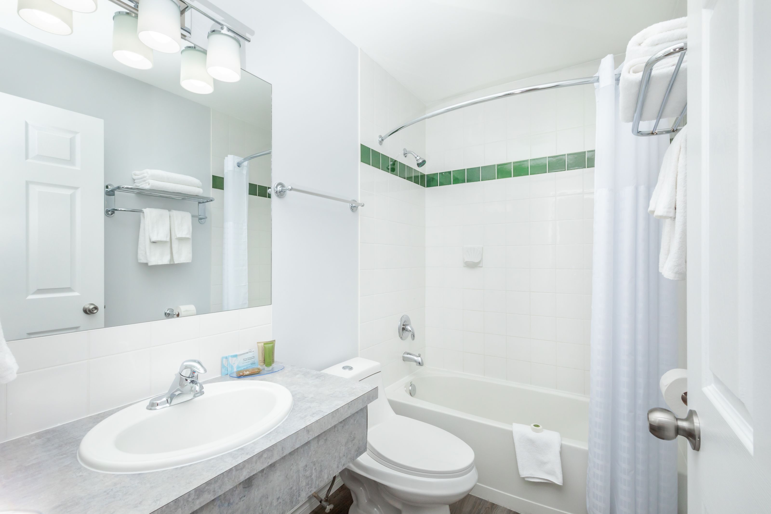 A bathroom with a sink, toilet, and shower.