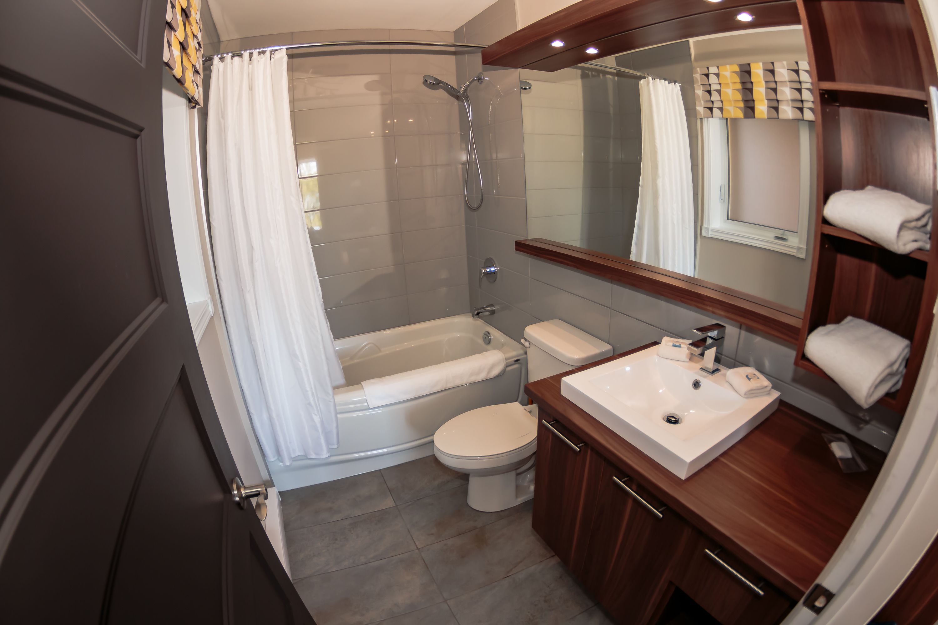Un baño moderno con ducha, inodoro y lavamanos.