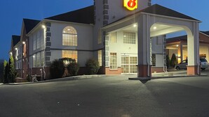 A Super 8 hotel with a large parking lot and a covered entrance.