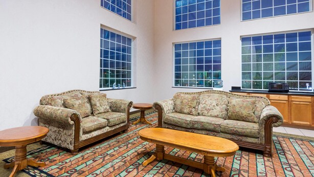 A room with two sofas, a wooden coffee table, and patterned carpet.