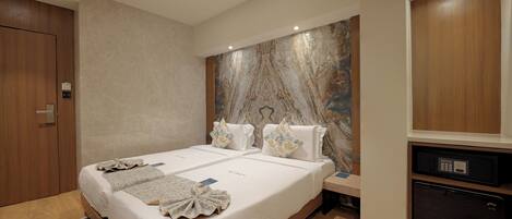 A hotel room with two beds, a marble accent wall, a wooden wardrobe, and a minibar.