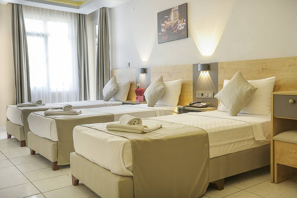 Une chambre d’hôtel avec deux lits, une table de chevet, une lampe et un tableau au mur.