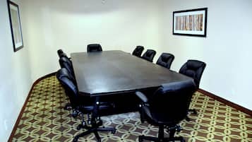 Una sala de conferencias con una mesa grande y ocho sillas.