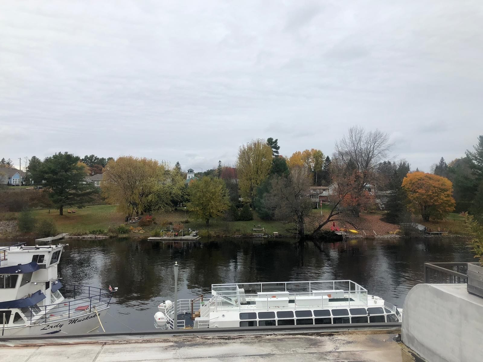 A river with a dock and a boat named 'Lady Muskie'.