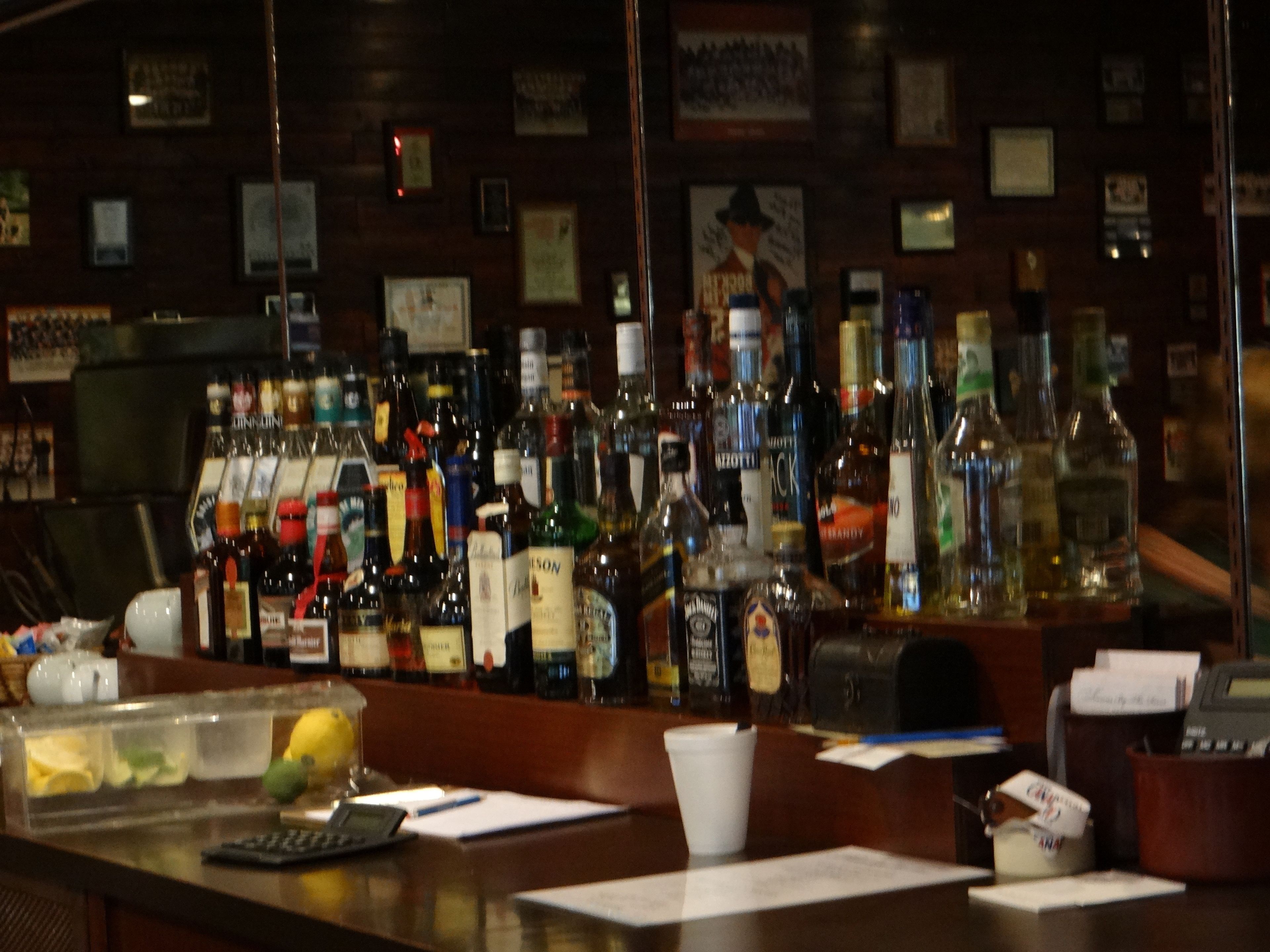 A bar with various liquor bottles and a cash register.