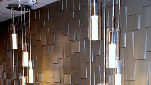 A wall with a geometric pattern and pendant lights.