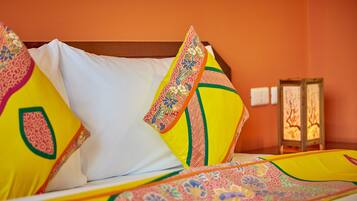 A bed with colorful pillows and a patterned bedspread.