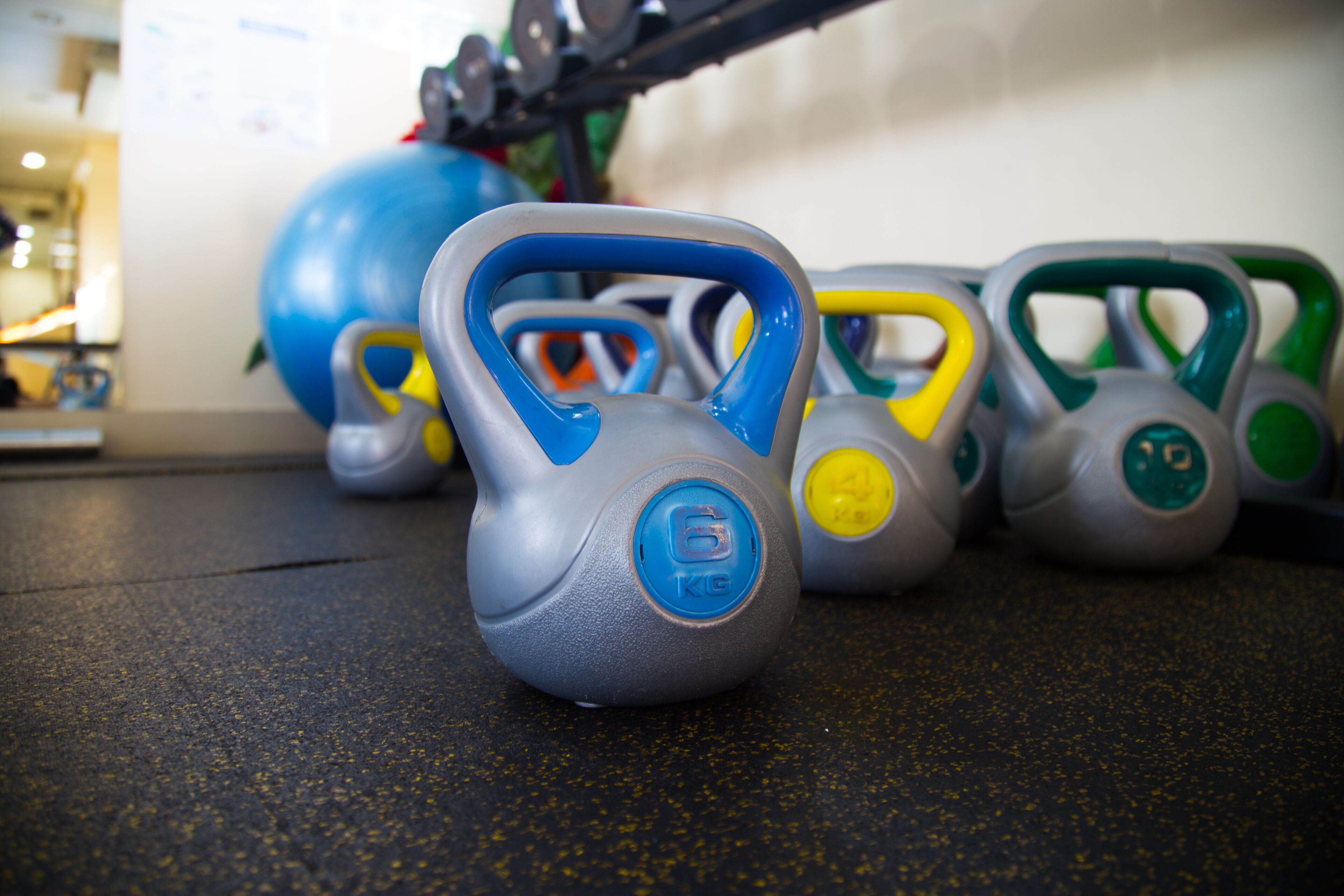 A set of kettlebells on a gym floor.