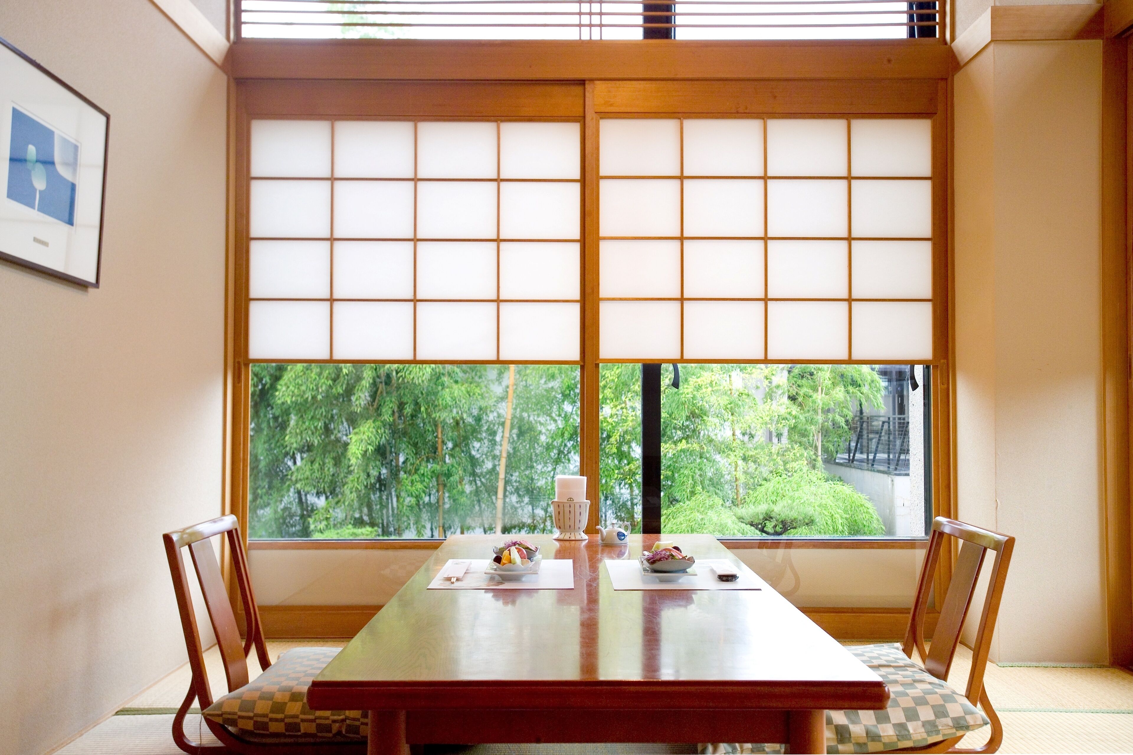 Una habitación japonesa tradicional con suelo de esteras de tatami, una mesa de madera baja y puertas correderas shoji.