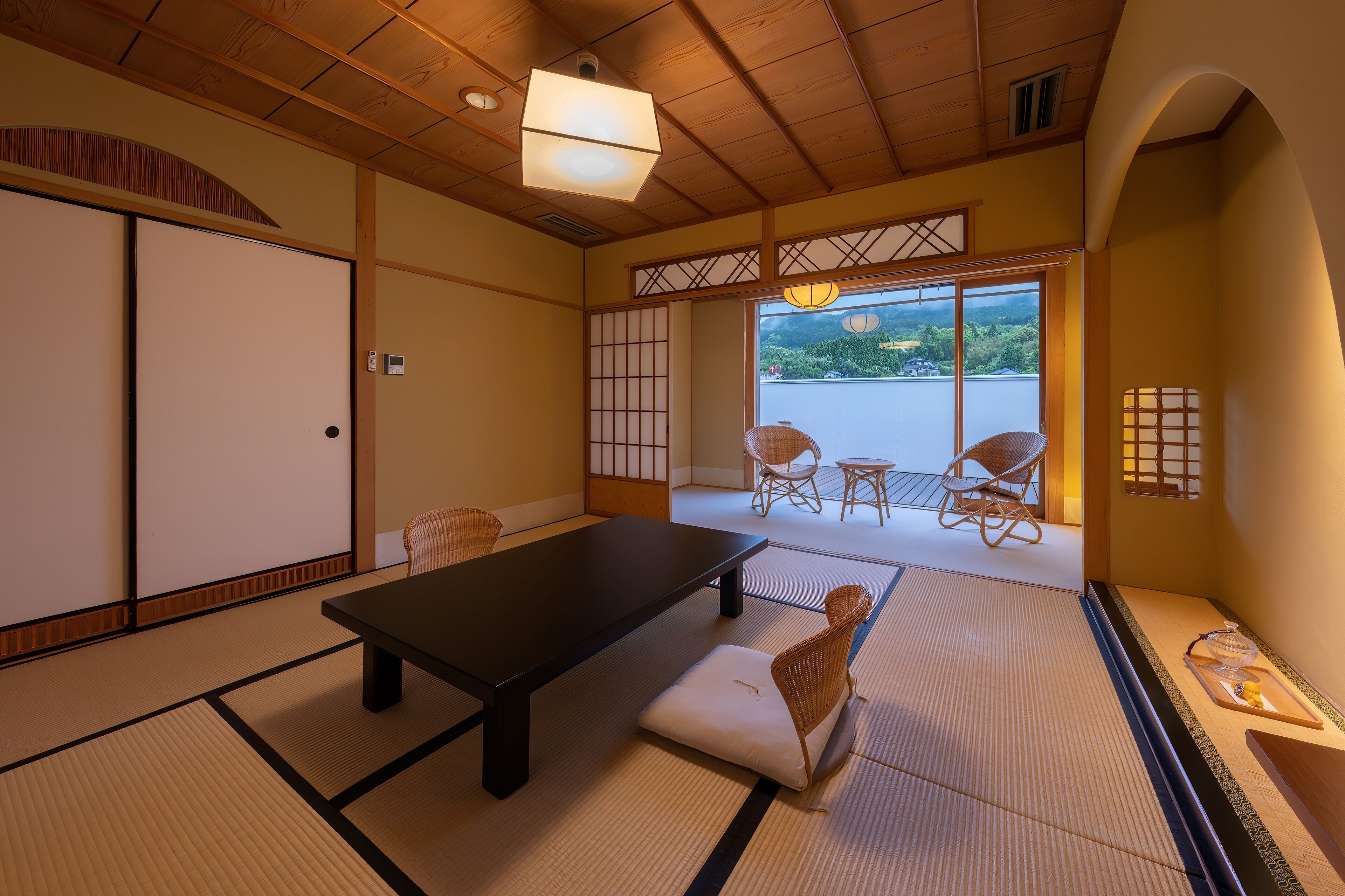 A traditional Japanese room with tatami flooring, a low table, and sliding doors.