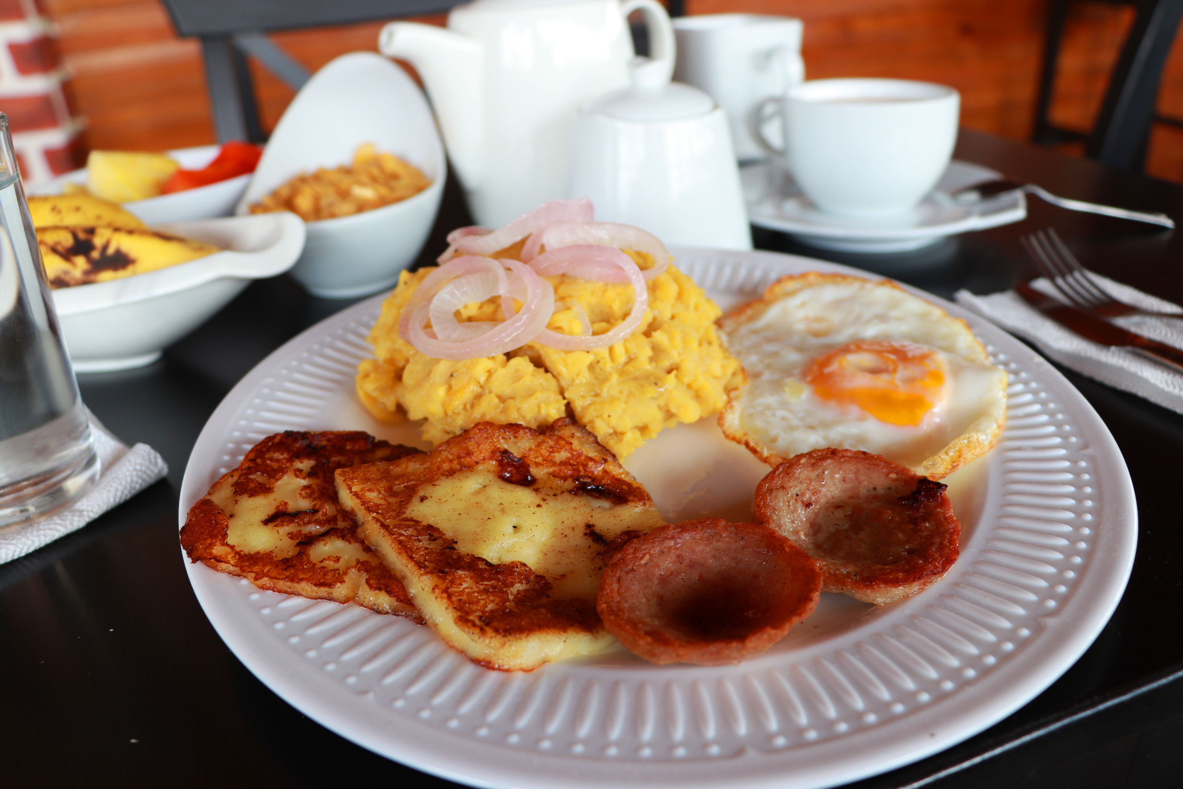 A breakfast plate with scrambled eggs, a fried egg, hash browns, and toast.