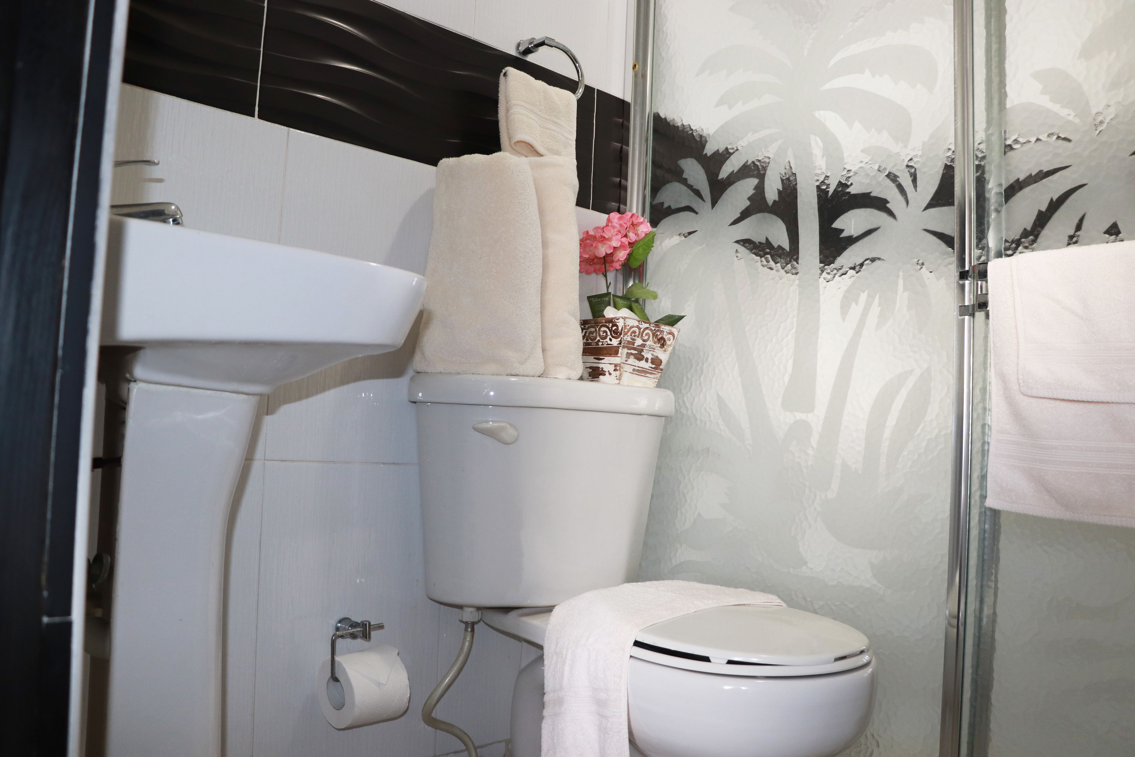 Un baño con inodoro, lavabo y ducha.