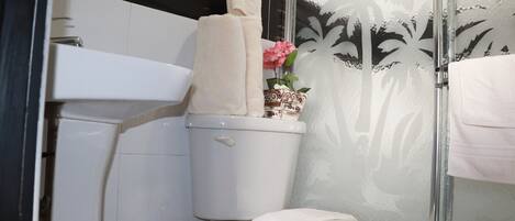 Un baño con inodoro, lavabo y ducha.