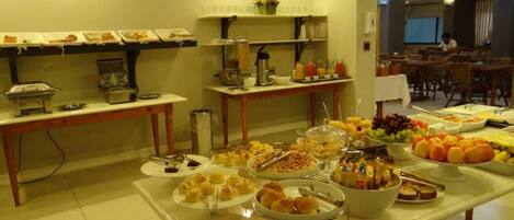 A buffet setup with various food items and a coffee station.