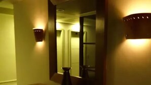 A dimly lit hallway with a bench, a mirror, and wall sconces. - Diamond Hotel (Rio de Janeiro)