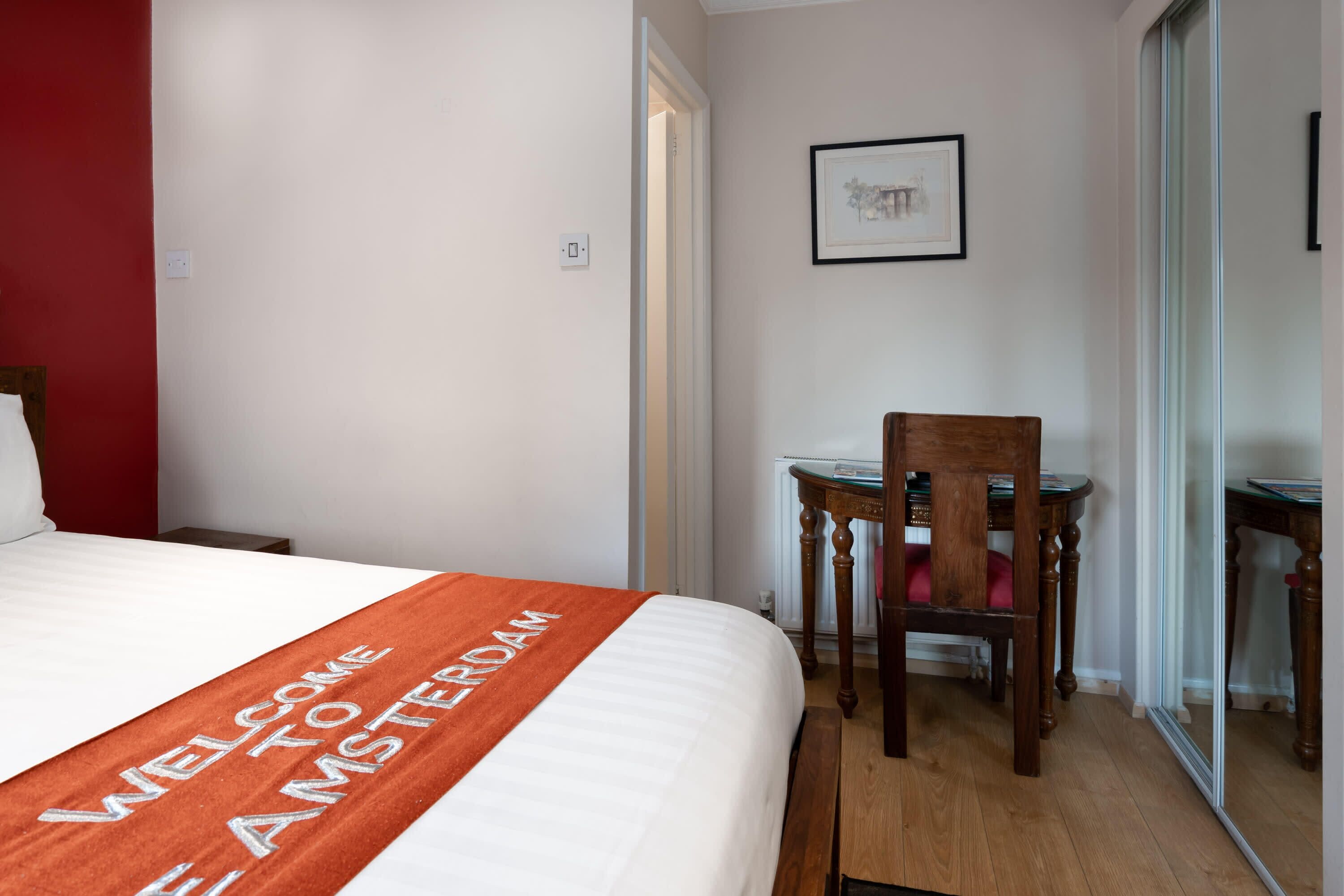 Una habitación de hotel con cama, escritorio y silla.