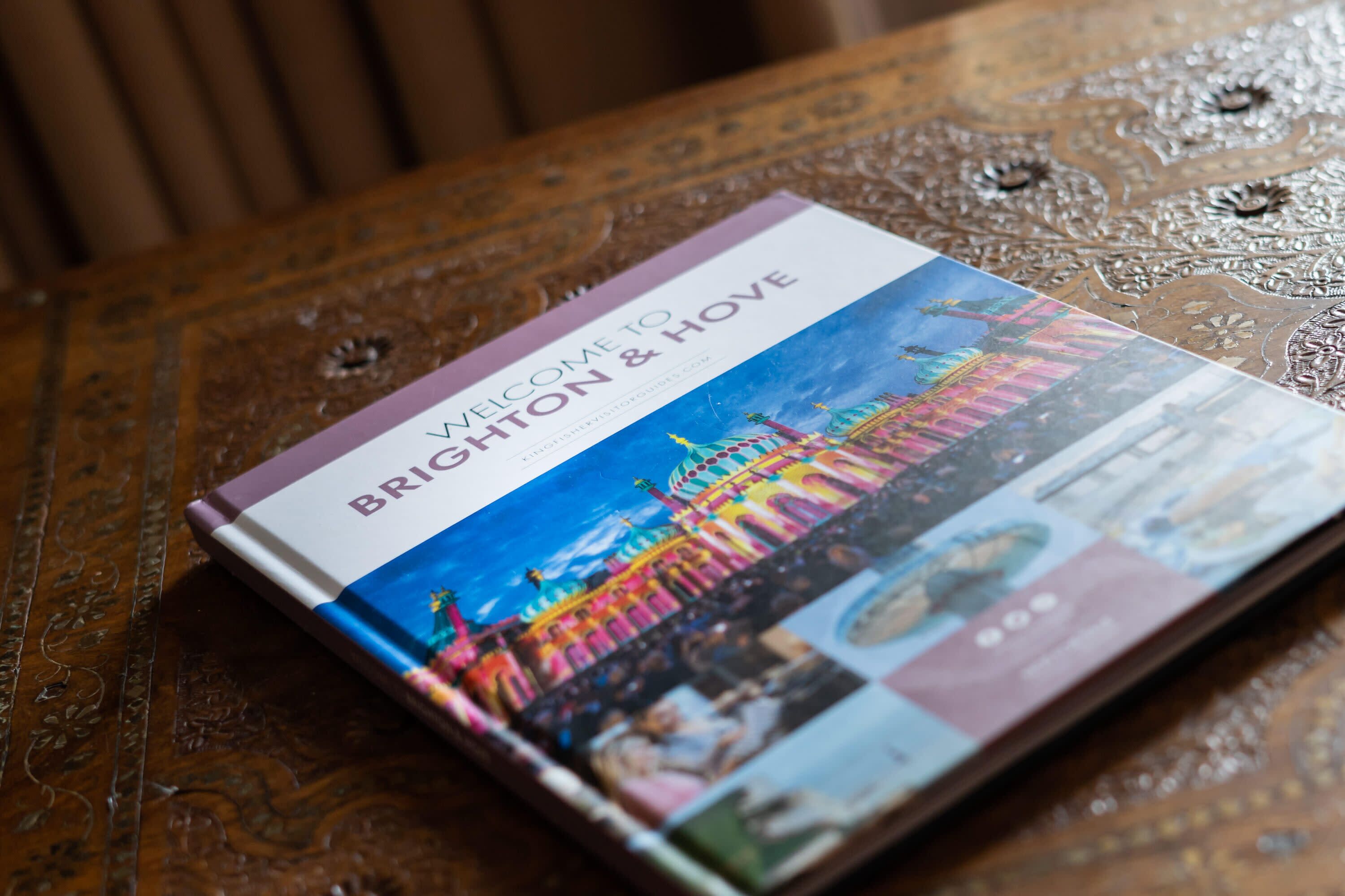 Une brochure intitulée « Bienvenue à Brighton et Hove » est posée sur une table en bois.